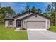 Attractive single-story home with a two-car garage, neutral color palette, and well-maintained landscaping at 7220 Swartburg Rd, North Port, FL 34291