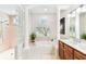 Bright bathroom with soaking tub, separate shower, double vanity, and window with decorative shutters at 15005 Lake Emerald Blvd, Tampa, FL 33618