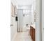 Bathroom featuring a shower-tub combo with white tile, wood vanity, and neutral tile floors at 15005 Lake Emerald Blvd, Tampa, FL 33618