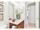 Bathroom featuring a vanity with decorative plants and mirrors, neutral tile floors, and a door leading to hallway at 15005 Lake Emerald Blvd, Tampa, FL 33618