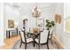 Elegant dining room featuring hardwood floors, white columns, a chandelier, and adjacent kitchen at 15005 Lake Emerald Blvd, Tampa, FL 33618