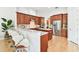 Open-concept kitchen featuring an island, bar seating, and stainless steel appliances at 15005 Lake Emerald Blvd, Tampa, FL 33618