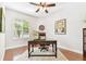 Cozy office space featuring hardwood floors, a ceiling fan, a vintage desk, and bright natural light at 15005 Lake Emerald Blvd, Tampa, FL 33618