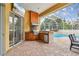 Outdoor kitchen includes stainless steel grill, granite counters, and views of the pool at 15005 Lake Emerald Blvd, Tampa, FL 33618