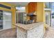 Outdoor kitchen featuring granite countertops, stainless steel grill and a bar for entertaining at 15005 Lake Emerald Blvd, Tampa, FL 33618