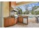 Outdoor kitchen with stainless steel grill, granite countertops, and screened lanai with pool view at 15005 Lake Emerald Blvd, Tampa, FL 33618