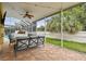 Covered patio with comfortable seating overlooking the screened-in pool and lush backyard at 15005 Lake Emerald Blvd, Tampa, FL 33618