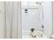 Bright shower-tub combo with white tiling, a shower caddy, and a decorative green plant at 15005 Lake Emerald Blvd, Tampa, FL 33618