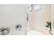A tiled shower with a rainfall shower head, handheld sprayer, a grab bar, and a built-in seat at 15005 Lake Emerald Blvd, Tampa, FL 33618