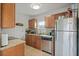 View of the kitchen with stainless steel refrigerator, dishwasher, granite countertops and natural wood cabinetry at 3030 5Th N Ave, St Petersburg, FL 33713