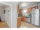 View of the kitchen with stainless steel refrigerator, tile floors, granite countertops and natural wood cabinetry at 3030 5Th N Ave, St Petersburg, FL 33713