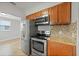 Kitchen featuring stainless steel appliances, granite countertops, and mosaic tile backsplash, adjacent to dining area at 3030 5Th N Ave, St Petersburg, FL 33713