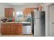 View of the kitchen with stainless steel refrigerator, dishwasher, granite countertops and natural wood cabinetry at 3030 5Th N Ave, St Petersburg, FL 33713