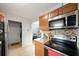 View of kitchen featuring stainless steel microwave and electric range, granite countertops, and wood cabinetry at 3030 5Th N Ave, St Petersburg, FL 33713