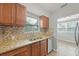 Kitchen featuring wood cabinets, granite countertops, stainless steel appliances, and mosaic tile backsplash at 3030 5Th N Ave, St Petersburg, FL 33713