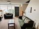 Comfortable living room with sofas, glass top table, and view to door at 4352 Tahitian Gardens Cir # E, Holiday, FL 34691