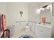This light-filled bathroom has tiled floors, a white vanity, updated lighting and grab bars at 458 Grant St, Dunedin, FL 34698