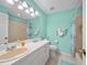 The bathroom boasts a single sink vanity, tiled shower and seafoam green painted walls at 458 Grant St, Dunedin, FL 34698