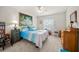 A bright bedroom boasts a ceiling fan, a picturesque painting, and a large window with blinds at 458 Grant St, Dunedin, FL 34698