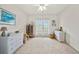 Bright bedroom featuring neutral carpet, ceiling fan, glass doors to lanai, and wicker furniture at 458 Grant St, Dunedin, FL 34698