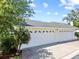 Spacious three-car garage with clean white doors and lush landscaping nearby at 458 Grant St, Dunedin, FL 34698