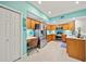Open concept kitchen with stainless appliances, white countertops, wood cabinets, tile flooring and a built in desk at 458 Grant St, Dunedin, FL 34698