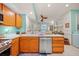 Bright kitchen featuring wooden cabinets, white countertops, stainless steel appliances and an open design to the living area at 458 Grant St, Dunedin, FL 34698