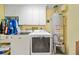 Laundry room with washer, dryer and white cabinets at 458 Grant St, Dunedin, FL 34698
