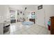 Bright living room with tile flooring, fan, and front door view with natural light at 458 Grant St, Dunedin, FL 34698