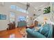 Bright living room with high ceilings, hardwood floors, large windows, comfortable seating, and a ceiling fan at 458 Grant St, Dunedin, FL 34698