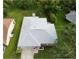 An aerial view of home with light gray roof, lush green yard, and mature trees at 8130 Merrimac Dr, Port Richey, FL 34668