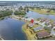 An aerial view showing a serene lakefront property nestled within a charming residential area at 1950 Sterling Glen Ct, Sun City Center, FL 33573