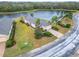 Beautiful home with a brick driveway, lush landscaping, and scenic lake views at 1950 Sterling Glen Ct, Sun City Center, FL 33573