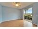 Bright bedroom featuring laminate flooring, a ceiling fan, and sliding glass doors to a tranquil view at 1950 Sterling Glen Ct, Sun City Center, FL 33573
