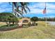 The Azalea Trace community sign is surrounded by lush landscaping and an American flag at 1950 Sterling Glen Ct, Sun City Center, FL 33573