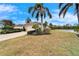 Well-maintained home exterior with lush landscaping, a paver driveway, and a picturesque lake view at 1950 Sterling Glen Ct, Sun City Center, FL 33573