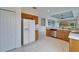 Bright kitchen with stainless steel dishwasher, tile flooring, and wood cabinetry at 1950 Sterling Glen Ct, Sun City Center, FL 33573