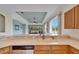Bright kitchen featuring wood cabinets, white countertops, and a double sink overlooking the backyard pond at 1950 Sterling Glen Ct, Sun City Center, FL 33573