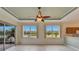 Bright living room with tile flooring, ceiling fan, lake view, and sliding door access to lanai at 1950 Sterling Glen Ct, Sun City Center, FL 33573