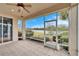 Screened in patio with tiled floor overlooking the backyard pond and lush landscaping at 1950 Sterling Glen Ct, Sun City Center, FL 33573