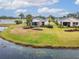A scenic view showing a house and its yard with a lake, complemented by lush landscaping at 1950 Sterling Glen Ct, Sun City Center, FL 33573
