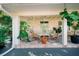 Relaxing covered patio with tiled floor, lounge furniture, and lush greenery creating a tranquil outdoor space at 4056 18Th S Ave, St Petersburg, FL 33711