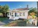 Charming home featuring a brick chimney, a landscaped yard, and a front door at 4056 18Th S Ave, St Petersburg, FL 33711