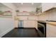 Modern kitchen features sleek cabinets, open shelving, stainless steel appliances, and black tile flooring at 4056 18Th S Ave, St Petersburg, FL 33711