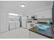 Efficient kitchen with white cabinets, laundry area, and modern appliances at 4154 Pinelake Ln # 101, Tampa, FL 33618