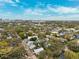 Stunning aerial view of a lush neighborhood with mature trees and city skyline in the background under a blue cloudy sky at 832 13Th N Ave, St Petersburg, FL 33701