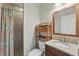 Bathroom with a wooden vanity, granite counters, storage shelves and tiled shower at 832 13Th N Ave, St Petersburg, FL 33701