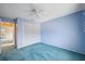 Bedroom featuring a ceiling fan, blue walls, and closet with sliding doors at 13000 Club Dr, Hudson, FL 34667