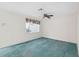 Bright bedroom featuring a ceiling fan, carpeted floor, and window with floral valance at 13000 Club Dr, Hudson, FL 34667