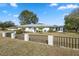 Wide exterior shot of well-maintained home featuring a dark metal and stone fence at 13000 Club Dr, Hudson, FL 34667